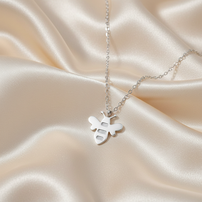 White Gold Honey Bee Pendant Necklace on luxe cream satin drape